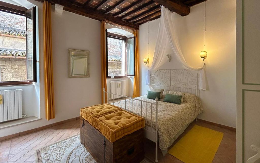 a bedroom with a bed in a room with windows at Santa Maria apartments in Todi