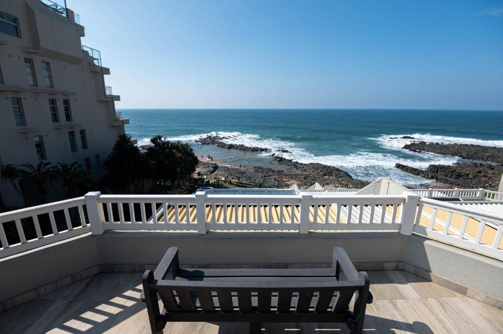 a bench sitting on a balcony looking at the ocean at Le Roc 10 in Ballito