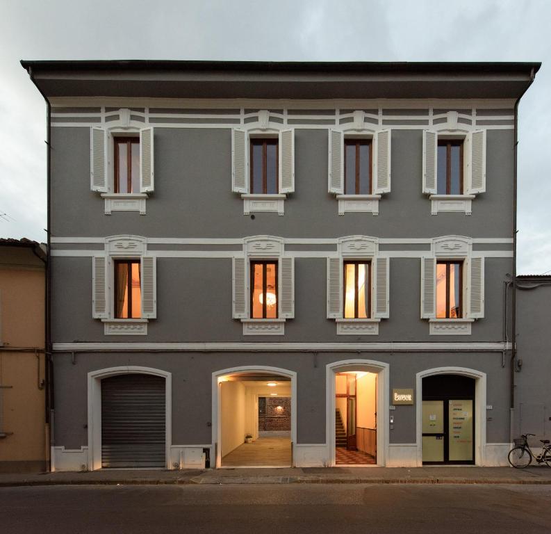 un edificio grigio con finestre e porte bianche di Residenza Cavour a Empoli