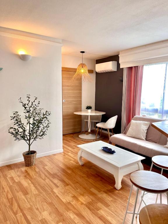 un salon avec un canapé et une table dans l'établissement PORT DE HYERES - Appartement 40m2 - 4 personnes - place de PARKING, à Hyères