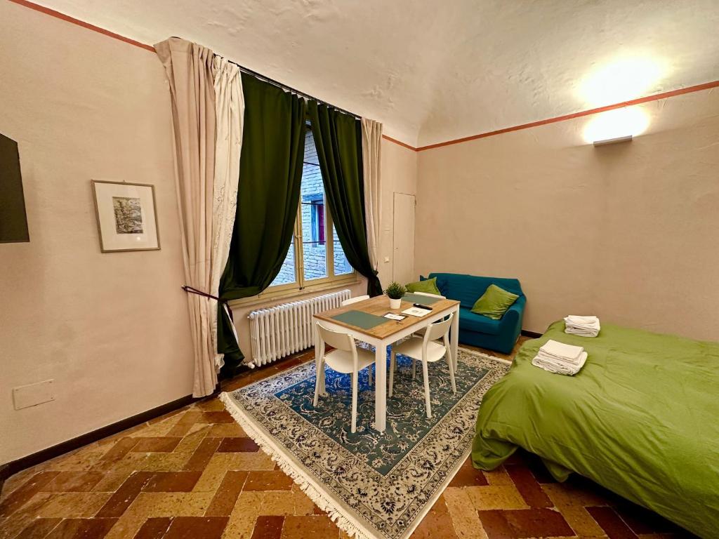 a bedroom with a table and a bed and a table and chair at Sancti Temporary Home Urbino in Urbino