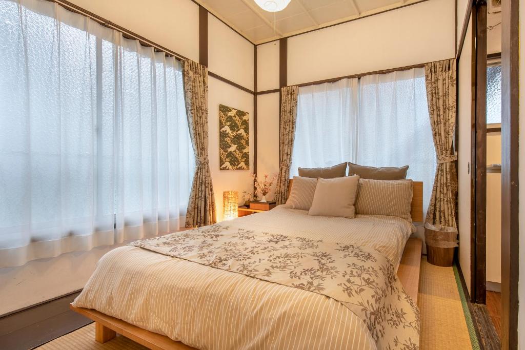 a bedroom with a large bed and windows at Central Panda Hotel in Tokyo
