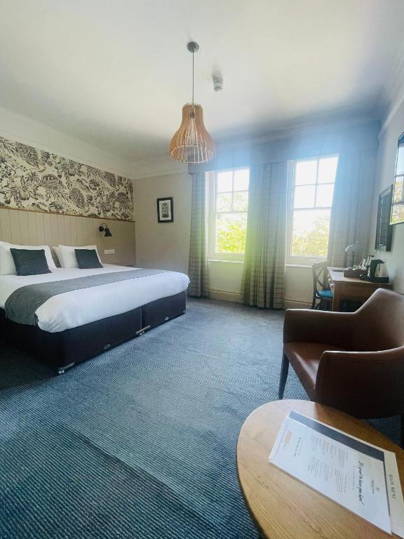 Un dormitorio con una cama, un sofá y una mesa. en Cedars Inn by Greene King Inns, en Barnstaple