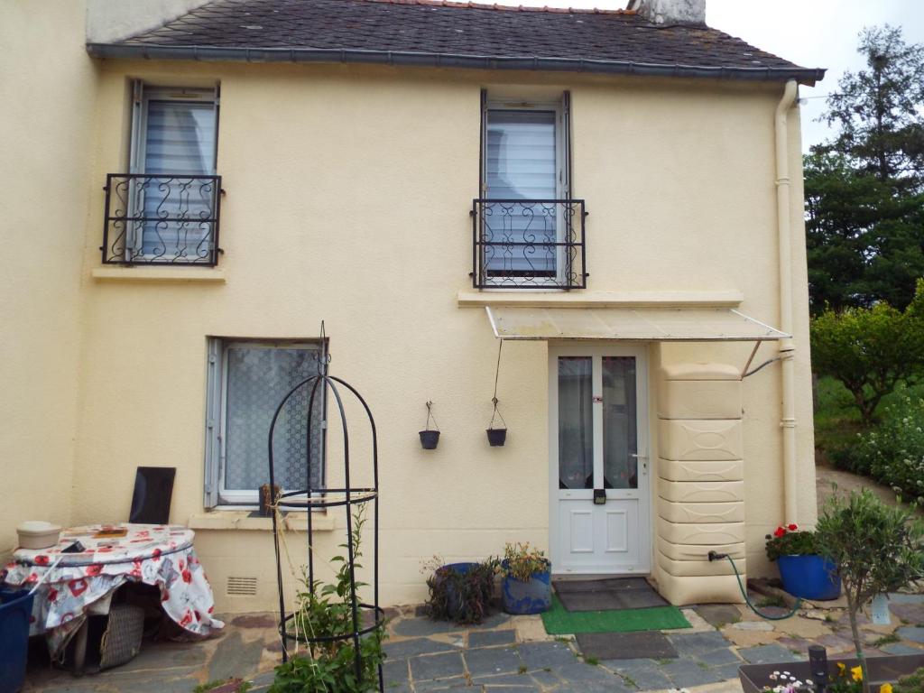 a yellow house with a table in front of it at Broceliande gite maison equipee 3 grandes chambres, chez papy et mamie in Loyat