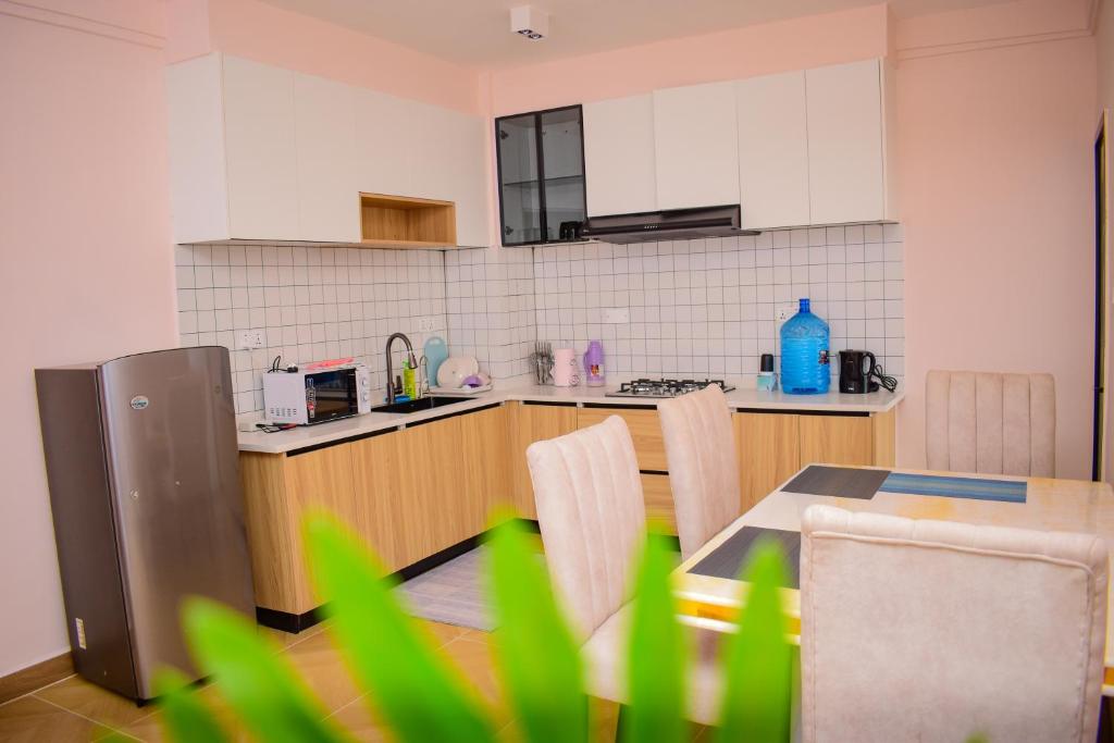 een keuken met een tafel en stoelen in een kamer bij Luxe Homes by cassie in Nairobi
