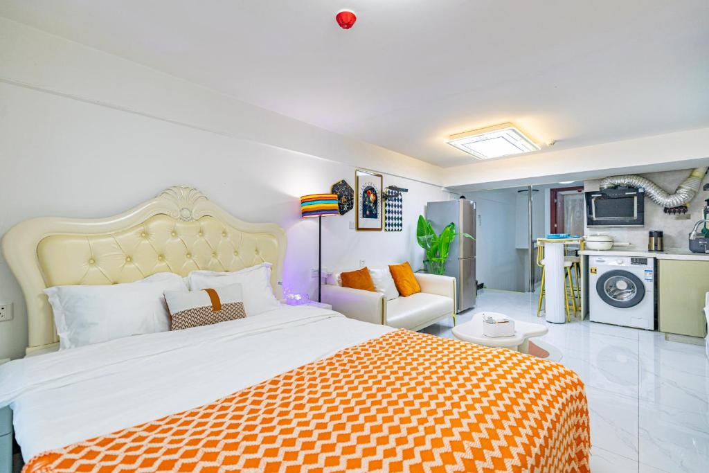 ein Schlafzimmer mit einem großen Bett mit einer orangefarbenen Decke in der Unterkunft Guangzhou City Center Apartment in Guangzhou