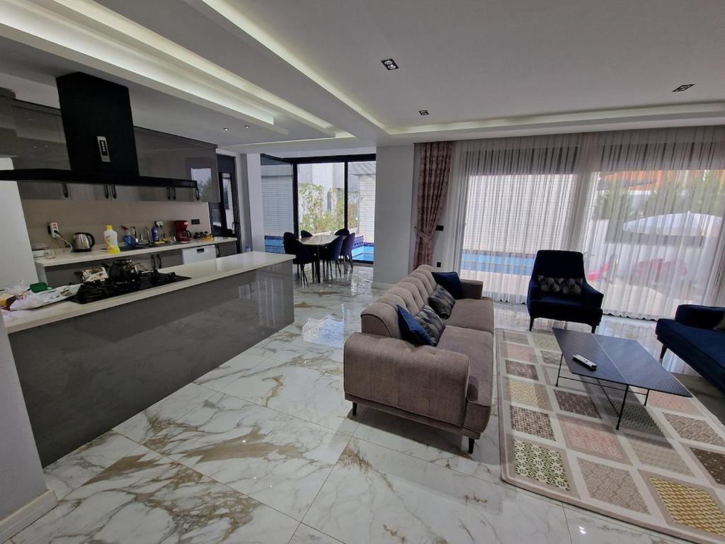 ein großes Wohnzimmer mit Couch und Küche in der Unterkunft Golden Life Family Villa 2 in Dosemealti