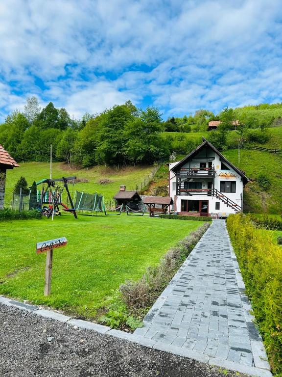 a house with a park with a playground at Colț Viu Cabana in Bran