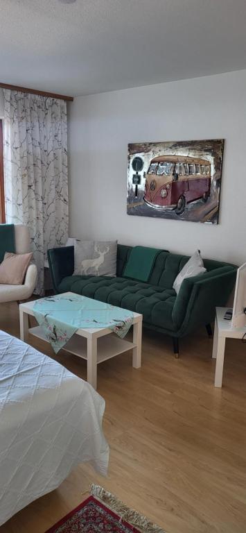 ミッセン・ヴィルハムスにあるFerienwohnung Morgentau mit Pool und Saunaの緑のソファとテーブルのあるリビングルーム