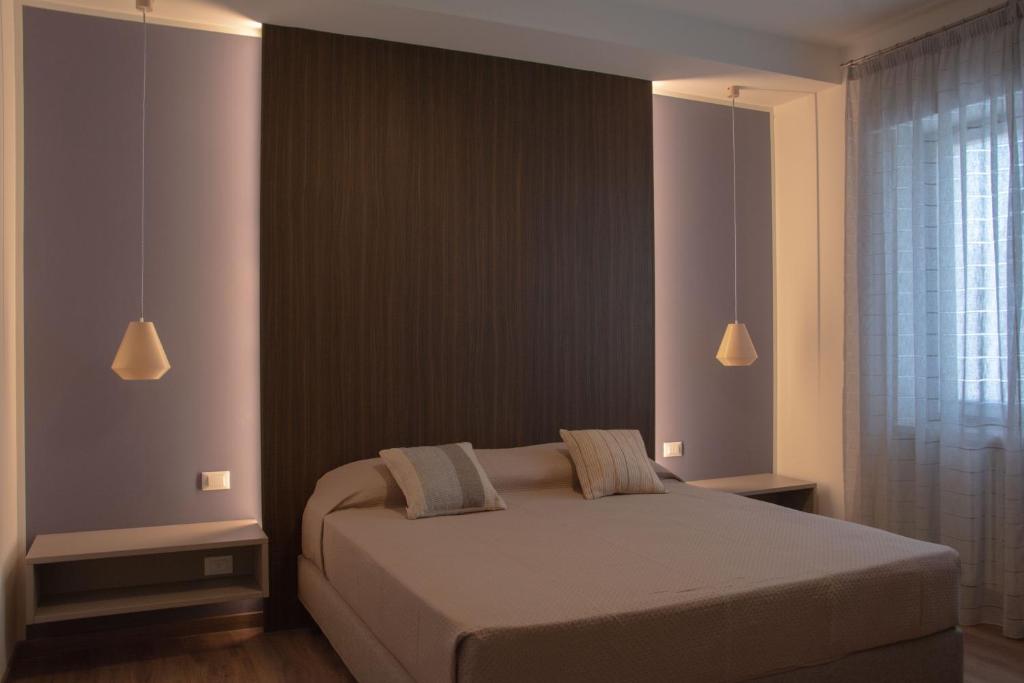 a bedroom with a bed with two lamps and a window at Blue Apartment - Verona&Lake in Bussolengo