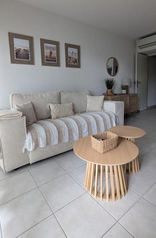 un salon avec un canapé et une table dans l'établissement Joli rez de jardin piscine, à Aigues-Mortes