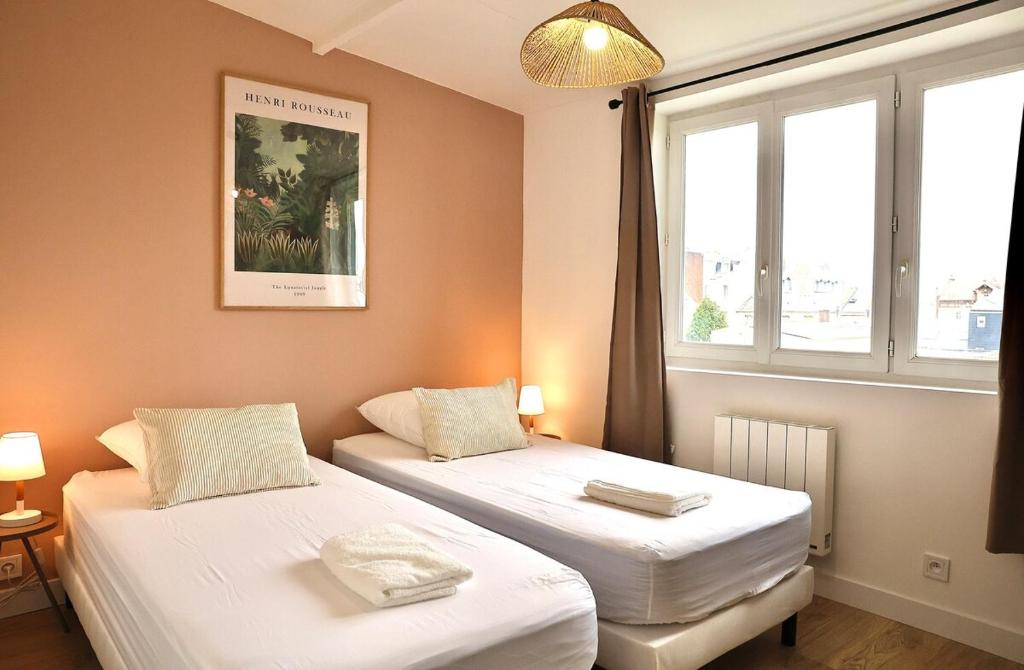 deux lits dans une chambre avec une fenêtre dans l'établissement Washington 3, au Havre