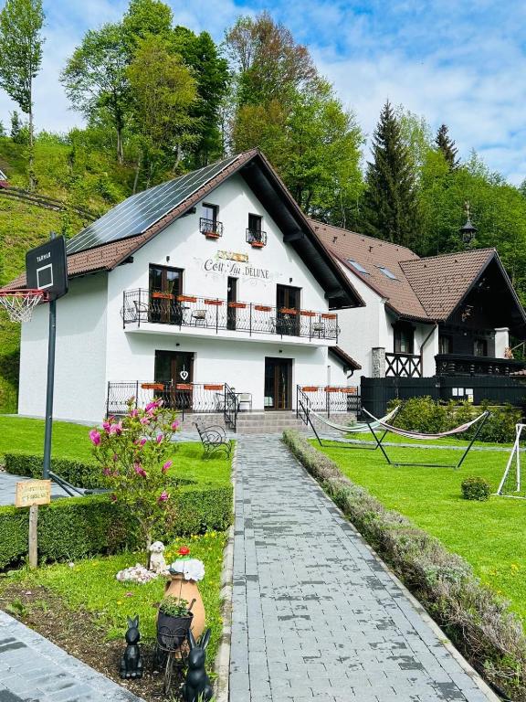a white building with a walkway in front of it at Colț Viu Deluxe in Şimon
