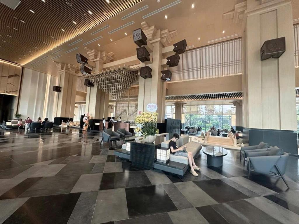 a lobby with people sitting on couches in a building at Wyndham Lynn Times Thanh Thuỷ Phú Thọ Hotel in Xuân Vi