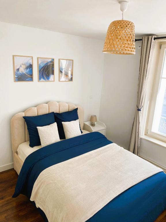 - une chambre avec un lit bleu et blanc et une fenêtre dans l'établissement Charming apartment in Nancy city center, à Nancy