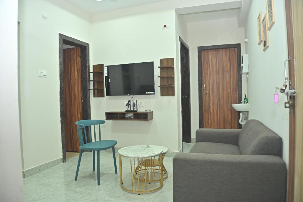 een woonkamer met een bank, een tafel en stoelen bij AVO Nest Kondapur - 1 BHK Fully Furnished Penthouse #601 in Kondapur
