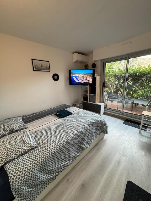 une chambre avec un lit et une télévision à écran plat dans l'établissement Studio Résidence Sainte-Maxime les Plages, à Sainte-Maxime