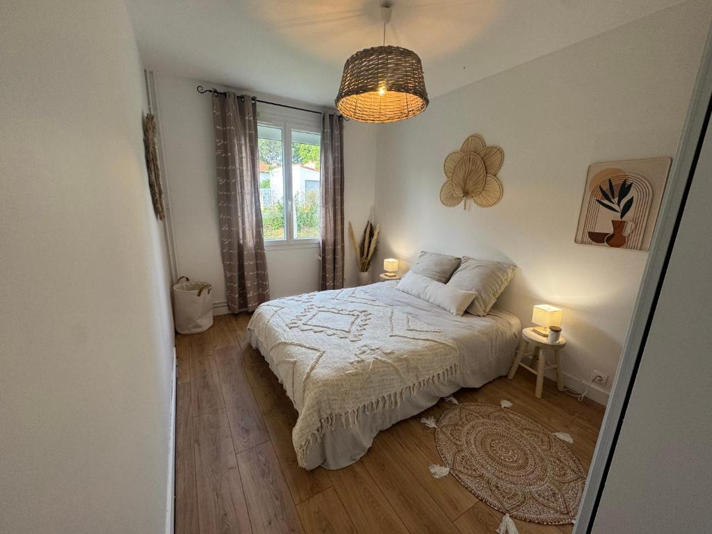 une chambre avec un lit et une fenêtre dans l'établissement Maison Le Verger de Manou, à Saint-Palais-sur-Mer