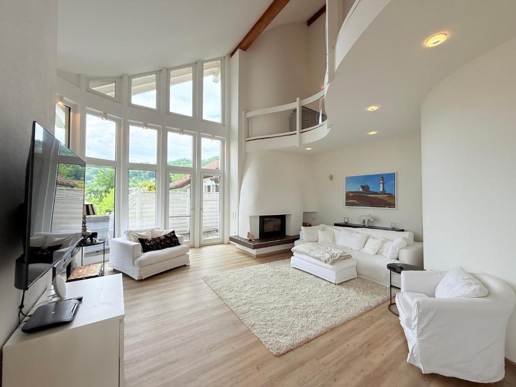 a living room with white furniture and a large window at Casa Braun in Bodman-Ludwigshafen