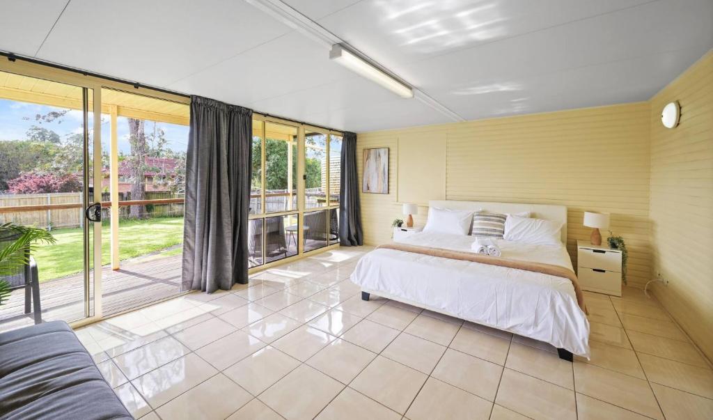 ein Schlafzimmer mit einem Bett und einem großen Fenster in der Unterkunft Private King Bed, Walk To Beenleigh Village&Museum Bedroom3 in Yatala