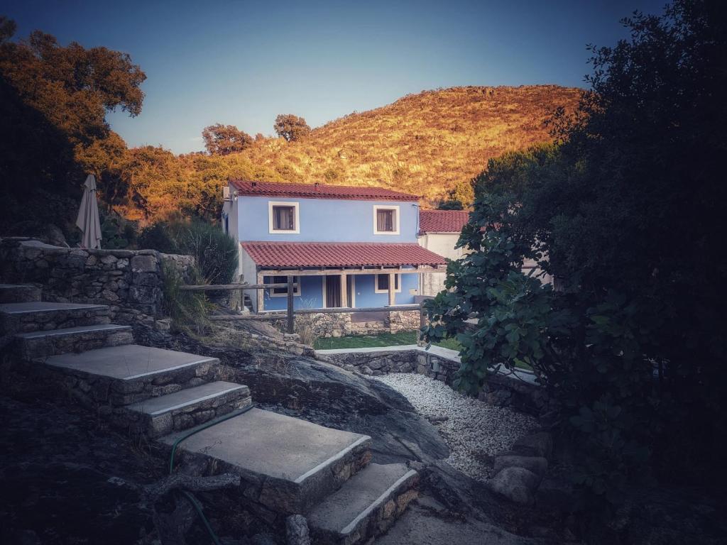 a house on a hill with stairs in front of it at Nidos del Buitre - Apartamentos Rurales in Valencia de Alcántara