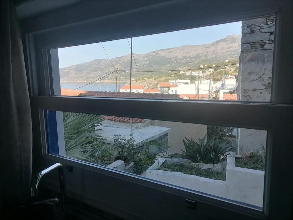 a view from a window with a view of the ocean at Γκαρσονιέρα δίπλα στην θάλασσα κ θέα στο λιμανι in Évdhilos