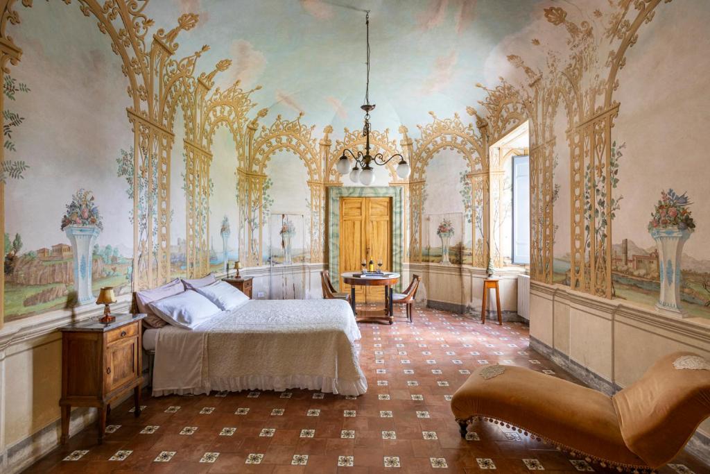 een slaapkamer met een bed en sierlijke plafonds bij Exclusive Apartment in an 1800s Frescoed Villa with Historic Park - Villa Mastrangelo in Colli del Tronto