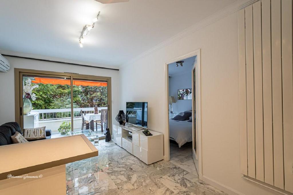 un salon avec un canapé et une télévision dans l'établissement Ô 27 Fleurie Cannes, à Cannes