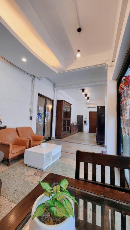 A narrow lobby seating area with two armchairs, a low table and a long view toward the reception area.