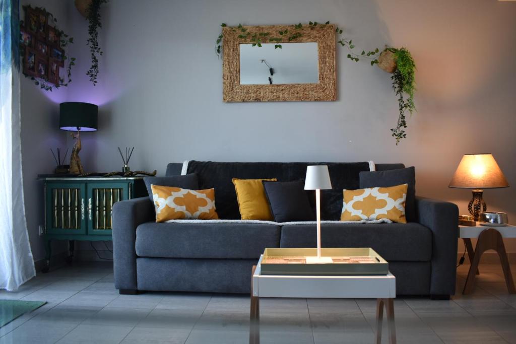 un salon avec un canapé bleu et une table dans l'établissement Studio Terrasse entre ville et port, à Porto-Vecchio