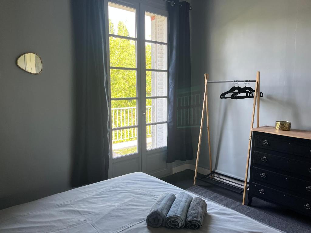 ein Schlafzimmer mit einem Bett, einer Kommode und einem Fenster in der Unterkunft Bord de l'eau, grand appartement in Saint-Pryvé-Saint-Mesmin