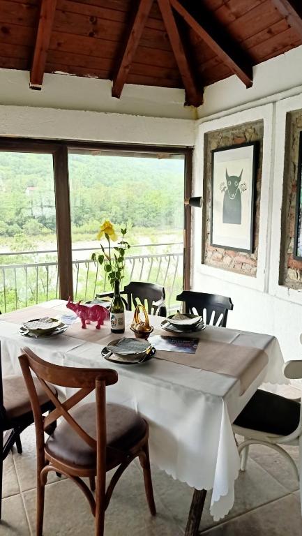 tavolo da pranzo con tovaglia e sedie bianche di Drina-Krivi Vir a Bajina Bašta
