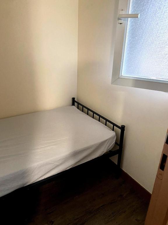 un lit dans une petite pièce avec une fenêtre dans l'établissement birdie-deauville, à Deauville