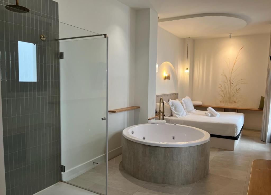a bathroom with a bath tub and a bed at Reina Victoria El Mercado in Alicante