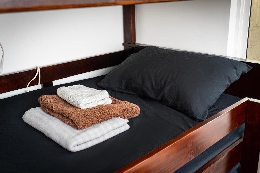 a bed with towels and pillows on it at Riverton Place NoHo in Los Angeles