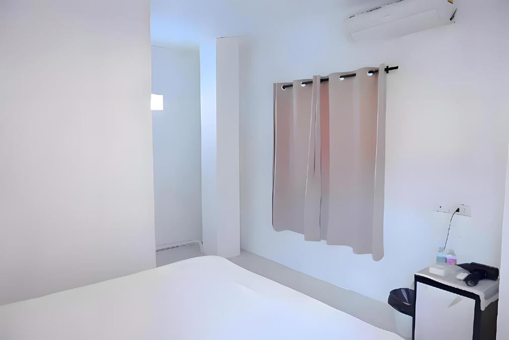 a white bathroom with a shower and a mirror at BAO Patong Beach Phuket - เบา ป่าตอง in Patong Beach