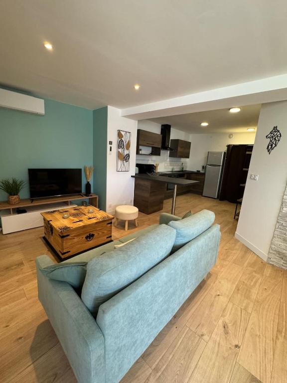 un salon avec un canapé bleu et une table dans l'établissement Escapade Marine, à Salles-sur-Mer
