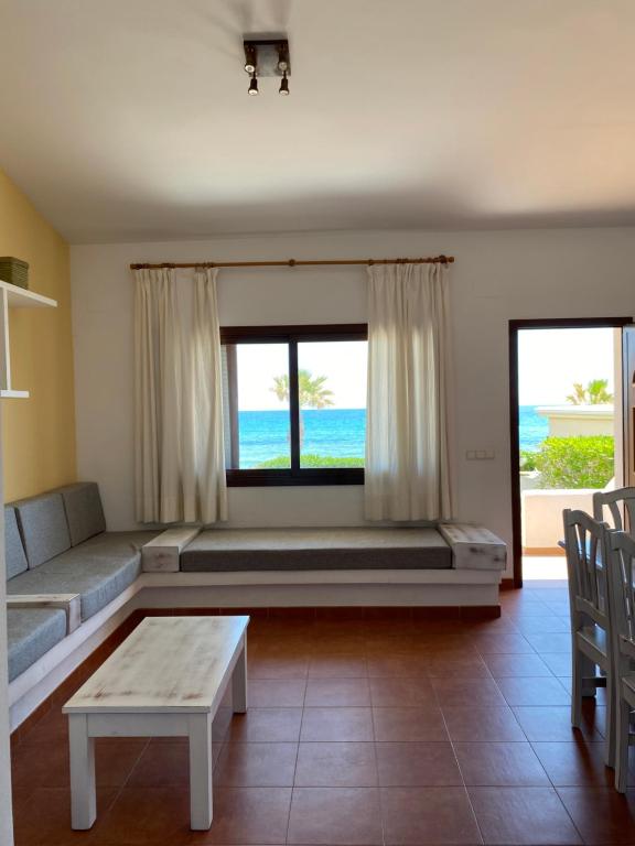 a living room with a bed and a large window at Apartamentos LLorca in Platja de l’Almadrava