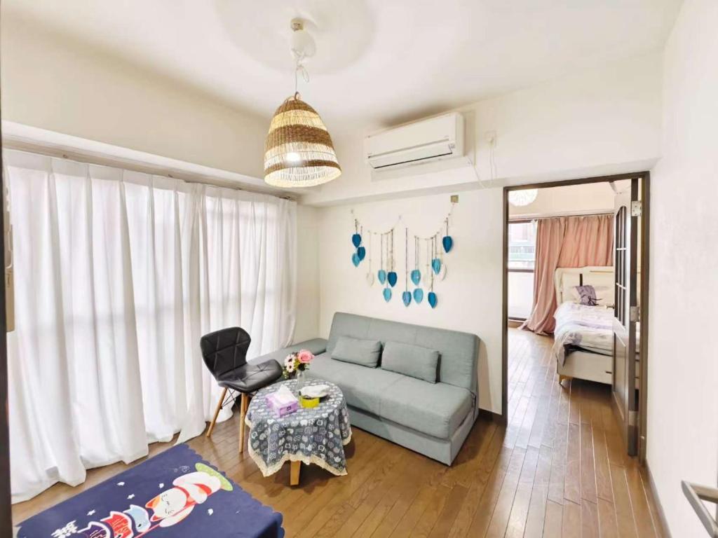 uma sala de estar com um sofá e uma mesa em Lucky sky903周围设施配套齐全1Ldk可容纳5人 徒步心斋桥商圈 高楼层俯瞰大阪 em Osaka