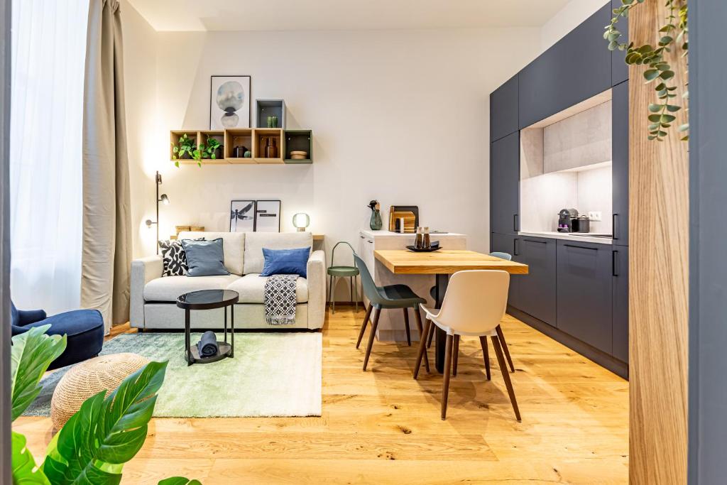 维也纳SUPERIOR DESIGN APARTMENT by JR City Apartments的配有桌子和沙发的厨房和客厅