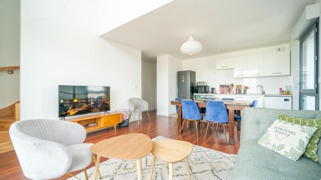 une cuisine et un salon avec un canapé et une table dans l'établissement Le ViewZen Duplex Asnières, à Asnières-sur-Seine