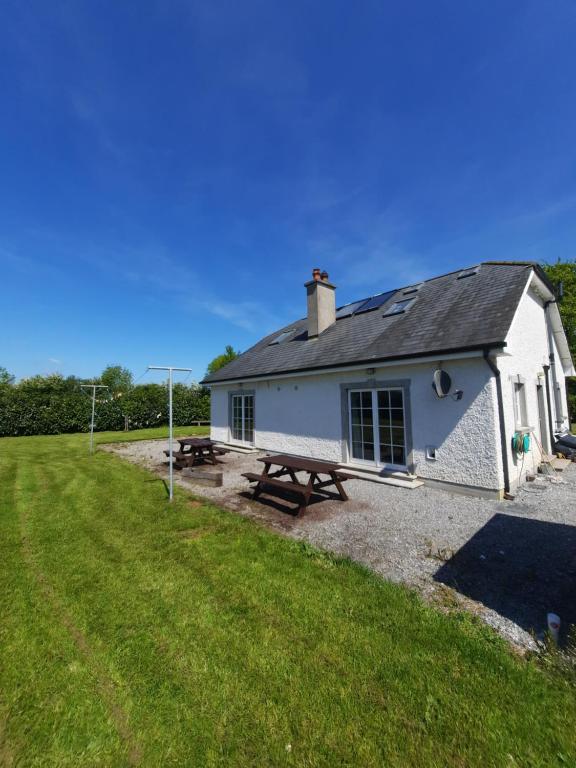 un edificio bianco con un tavolo da picnic di fronte di Clone manor Lodge a Ballyragget