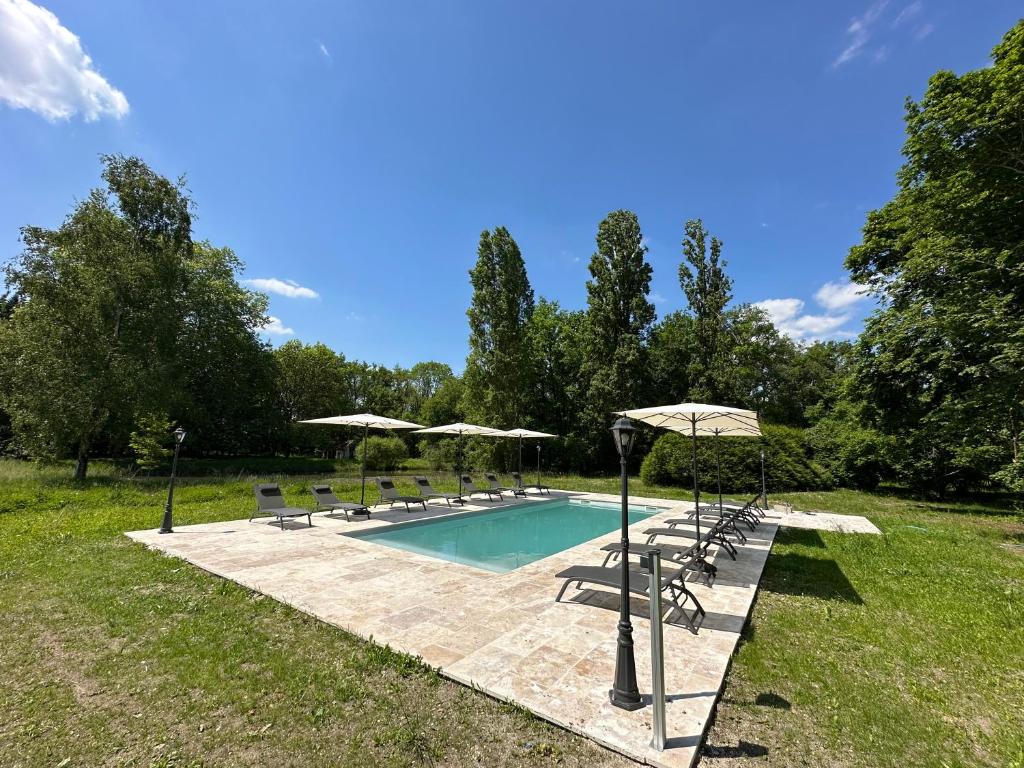 una piscina con sillas y sombrillas en Domaine de Chevillons, en Chevillon-sur-Huillard