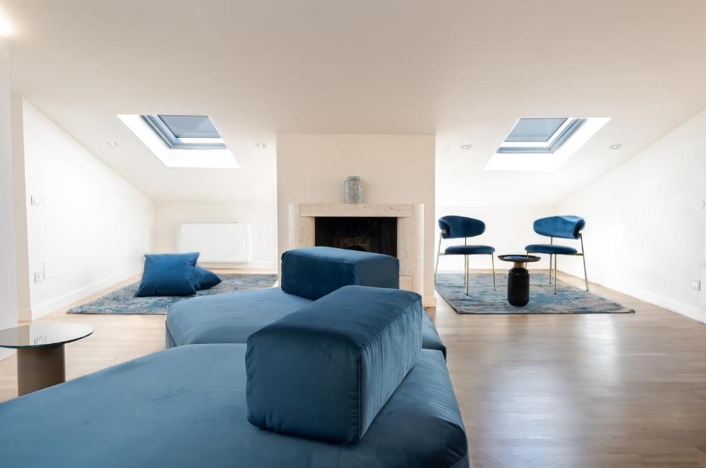 佩鲁贾Scappo in Umbria, L'attico del corso的一间白色的房间，里面有一张床、几把椅子和一个壁炉