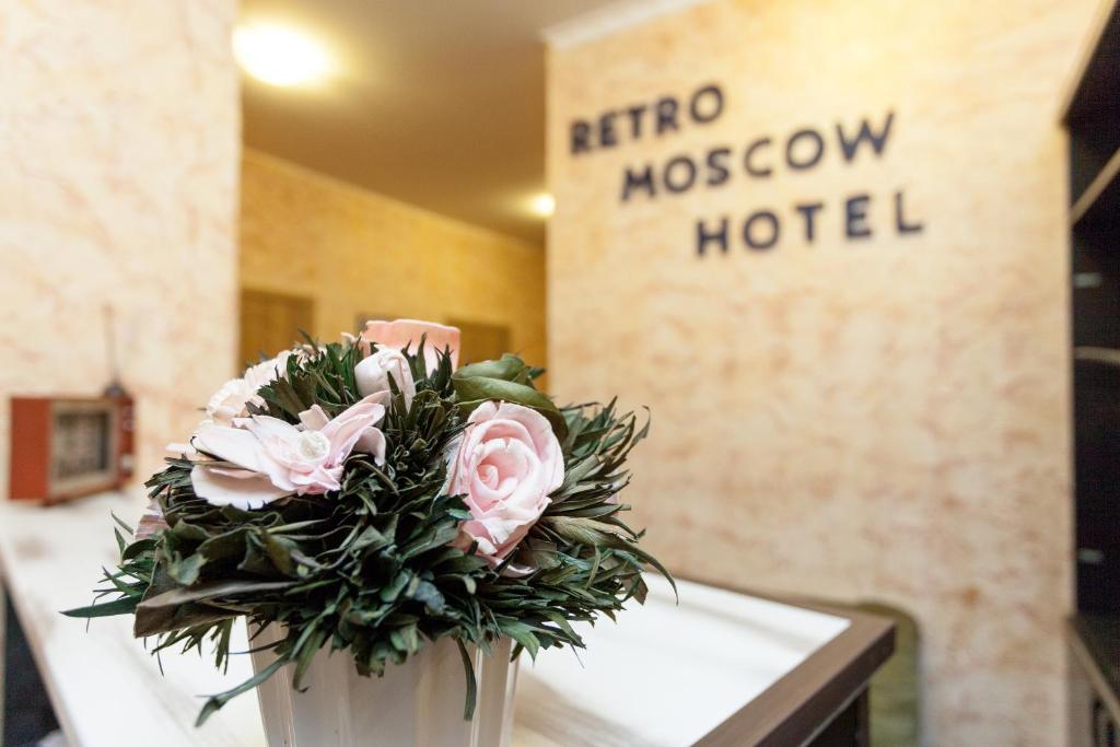 モスクワにあるレトロ モスクワ ホテル オン アルバートのホテルのテーブルに座る花瓶