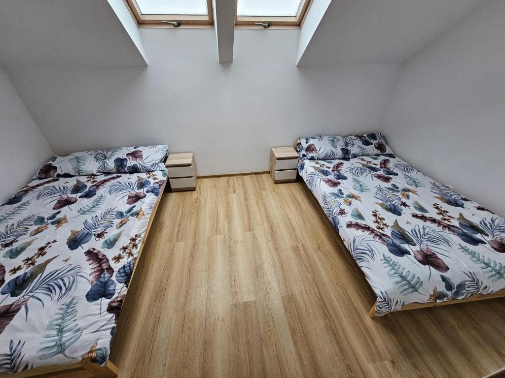 sypialnia z 2 łóżkami i drewnianą podłogą w obiekcie Baltichouse Podczele- domki wakacyjne blisko morza !!! sauna, jacuzzi,grill plac zabaw w Kołobrzegu