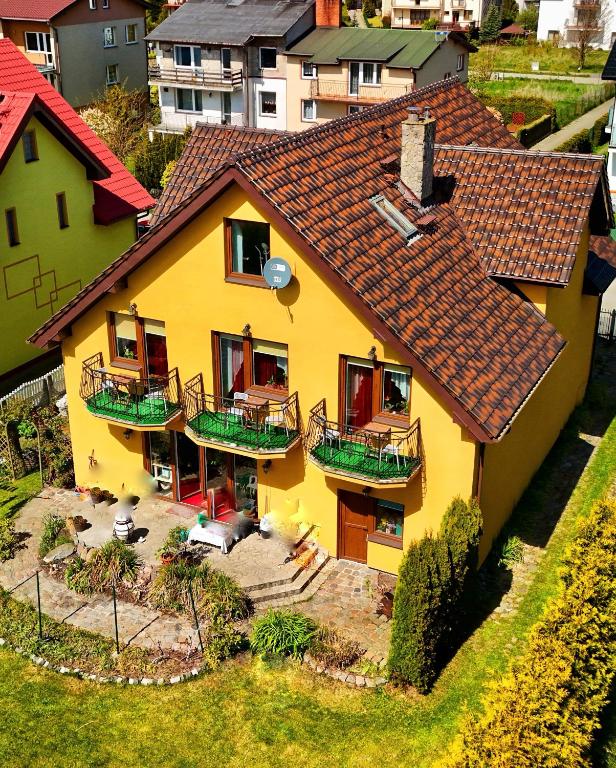 a yellow house with a red roof at Red Rose in Władysławowo