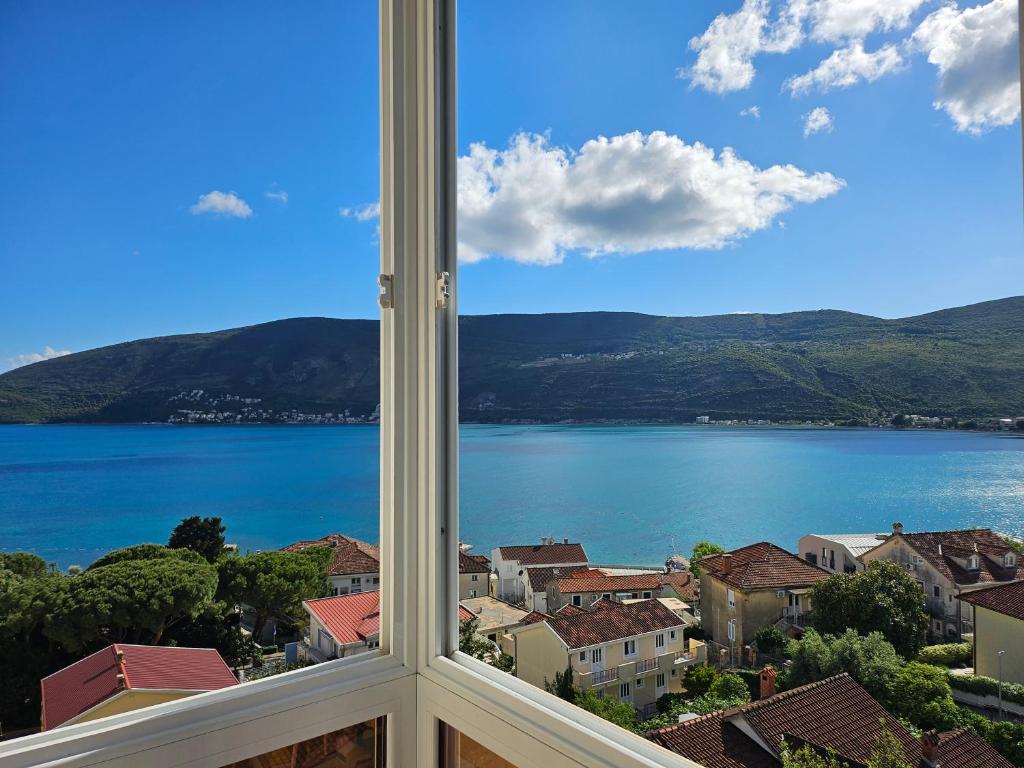 a view of a lake from a window at Apartman Mano in Topla