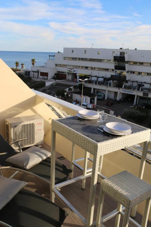 - une table sur un balcon avec vue sur l'océan dans l'établissement Studio 20, Héliopolis D au village naturiste, au Cap d'Agde