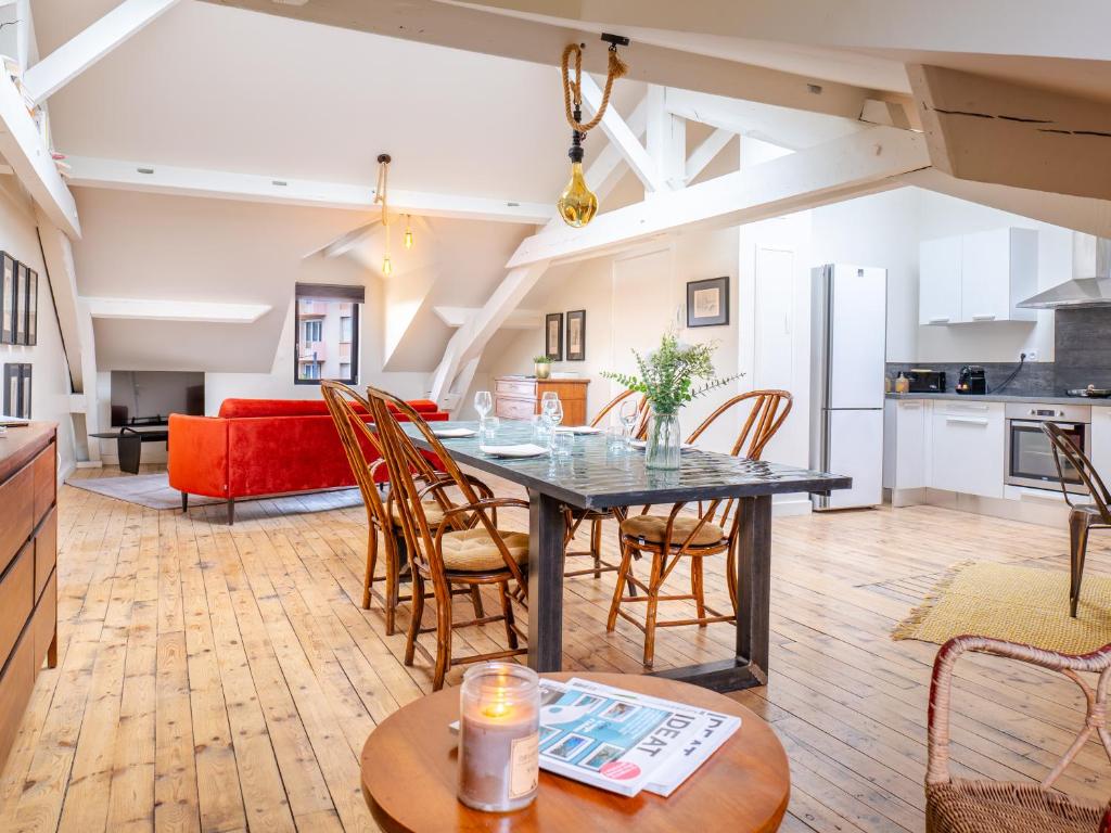 a kitchen and living room with a table and chairs at Nid douillet climatisé et lumineux, proche centre in Romans-sur-Isère